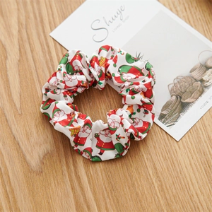 Primer plano de un coletero festivo con diseño de Papá Noel sobre una mesa de madera