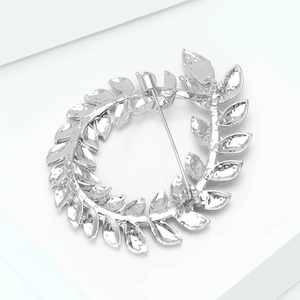 Detail shot of the polished silver olive branch wreath brooch with rhinestones