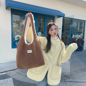 Close-up of brown faux shearling tote bag with soft fleece lining and minimalist label