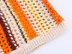 Gros plan détaillé du tissu en maille crochetée rayée orange jaune et marron