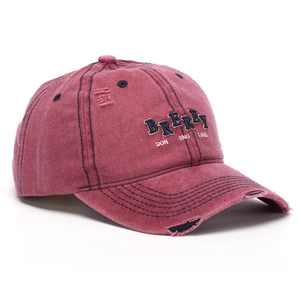 Detailed close-up of blue 3D letter embroidery on vintage washed distressed baseball cap