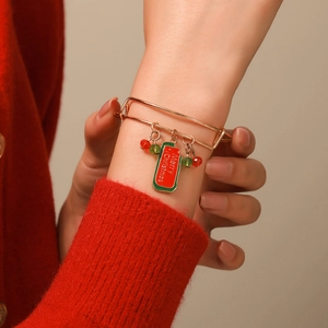 Adjustable Christmas bracelet with gold beads and Merry Christmas pendant worn by a model