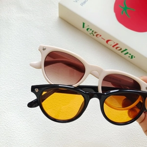 Detail of cream and black cat-eye sunglasses featuring heart-shaped metal accents