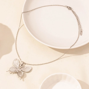 Detailed macro view of silver butterfly necklace showing S925 engraving on the extension chain
