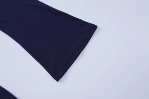 Gros plan détaillé de la manche de robe en tricot bleu marine avec ourlet à double couture