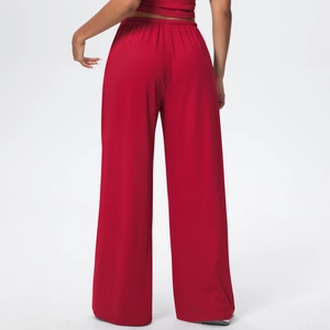 Detail of red wide-leg lounge pants showing the elastic high waist and draped fabric