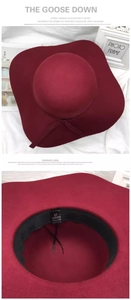 Detail view of burgundy wide-brim wool hat with 100% polyester wash label and sizing