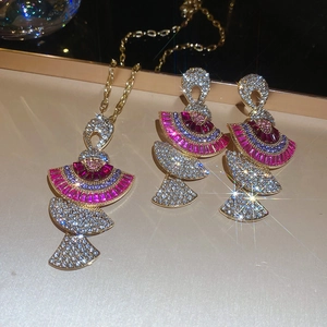 Detailed view of fan-shaped jewelry set with pink and purple rhinestones on gold base