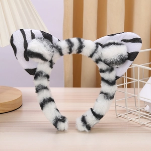 Detail of plush cat ear headband featuring a black and white zebra pattern on a table