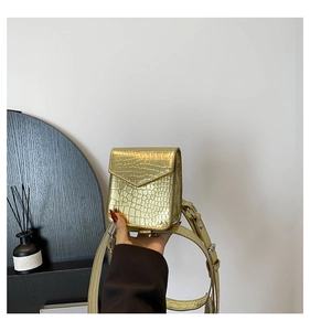 Vue détaillée du mini sac bandoulière doré avec gaufrage crocodile brillant et lanière