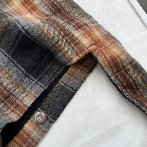 Macro view of the plaid wool fabric texture and silver magnetic snap button detail