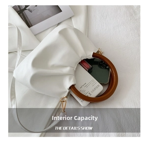 Detail of white pleated cloud bag showing interior capacity for phone and accessories