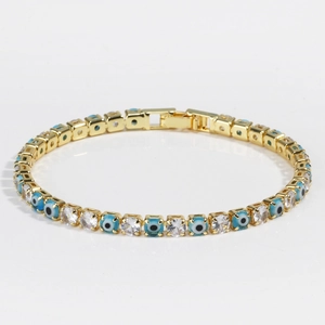 Detail of gold evil eye tennis bracelet with blue enamel charms and zircon stones