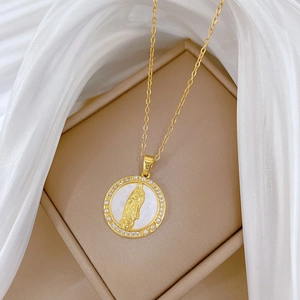Close-up of gold-plated portrait pendant with pearls and crystals on a jewelry box