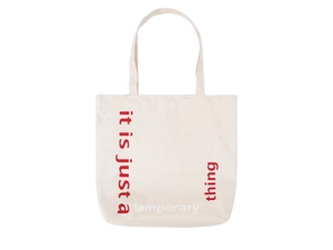 Detail of canvas tote bag featuring red and black Slogan print and durable handles