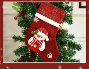 Detailed view of a red Christmas stocking with 3D snowman hanging on a festive tree