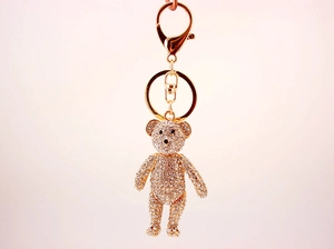 Detailed close-up of a gold teddy bear keychain fully encrusted with sparkling crystals