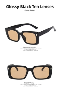 Detail view of rectangular sunglasses with black frames, rivets, and brown lenses