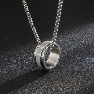Macro shot of silver stainless steel rotating ring pendant with engraved Sanskrit symbols