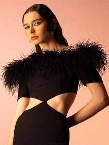 Detail of elegant black dress showing feather neckline and cutout waist design