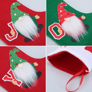 Detail of red and green felt Christmas stocking with JOY lettering and gnome pattern