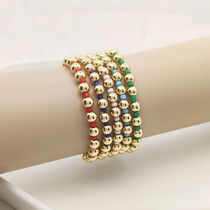 Close-up of 5-piece 18K gold beaded elastic bracelets with colorful spacer beads