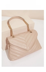 Macro view of beige V-shaped quilted texture and premium soft faux leather bag finish