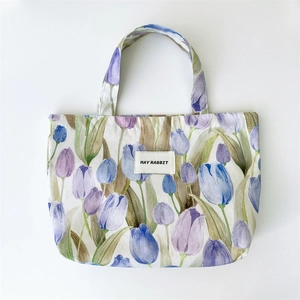 Detailed shot of the tulip pattern canvas tote bag with May Rabbit label on white surface