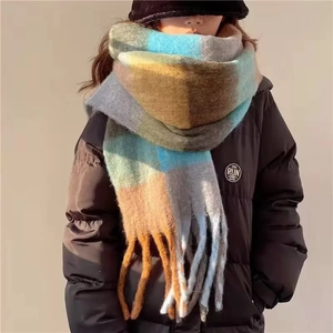 Detail of colorful plaid scarf with soft tassels showing thick rainbow mohair texture