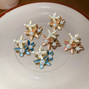 Detailed macro view of 18K gold plated flower earrings with pearls and colorful enamel petals