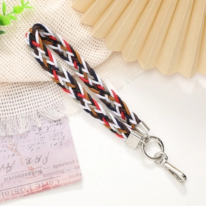Close-up of colorful braided wrist strap with silver metal clasp and rustic decor