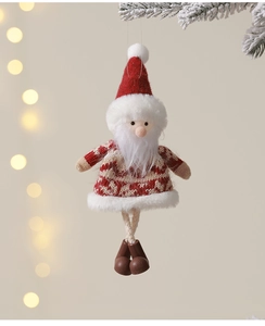 Detail of Santa plush ornament with red felt hat and wooden feet on snowy branch