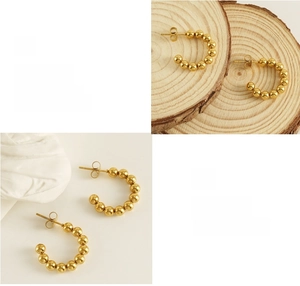 Detailed view of C-shaped 18K gold beaded stud earrings with a high-polished finish