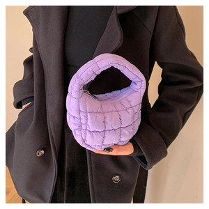 Detail of purple quilted cloud bag with padded texture and mini top handle design