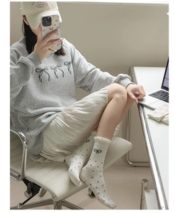 On-foot view of white mid-calf socks with black polka dots and cute bow accents