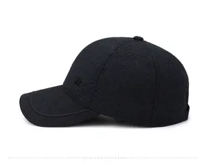 Detail of winter baseball cap showing textured fabric and metallic M logo on the side