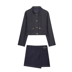 Détail de la texture denim bleu foncé et des coutures contrastées sur l'ensemble veste et jupe