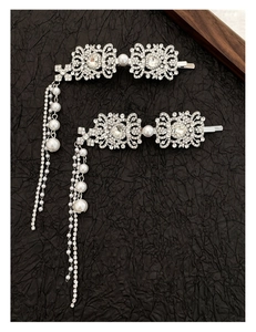Detailed macro shot of silver flower hair clips with rhinestones and pearl tassels