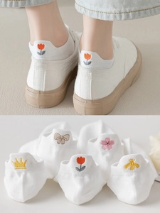 Detail of white mesh socks with embroidered heart and crown patterns for women