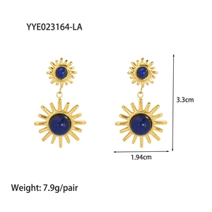 Détails de boucles d'oreilles soleil dorées serties de pierres de lapis-lazuli bleues