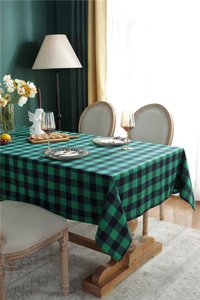 Detailed view of green and black plaid cotton tablecloth on a wooden dining table