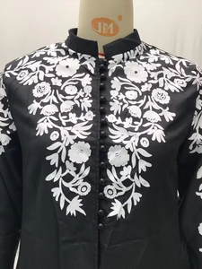 Detail van etnische jurk met opstaande kraag en decoratieve zwarte parelknoppen