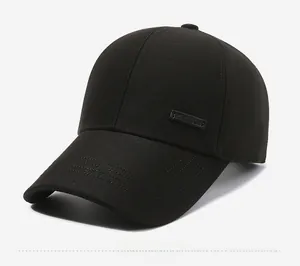 Detail of black cotton twill baseball cap with embossed leather logo patch and stitching