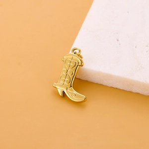 Vue détaillée d'un pendentif botte de cowboy en acier inoxydable doré avec gravures fines