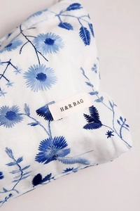 Détail de broderie florale sur sac en coton et lin avec étiquette de marque H&R BAG