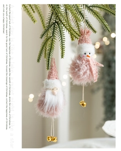 Pink plush Santa and snowman ornaments with bells hanging on green pine branches