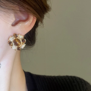 Detail of vintage flower cluster earring with faux pearls on model ear lobe