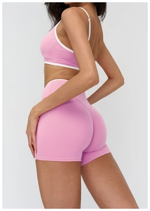 Détail du short de yoga rose avec bordure contrastée blanche et taille haute croisée
