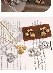 Flat lay of delicate cherry jewelry sets with zircon stones in gold and silver finish