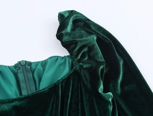 Detail of dark green velvet dress featuring puff shoulder pleats and invisible zipper closure